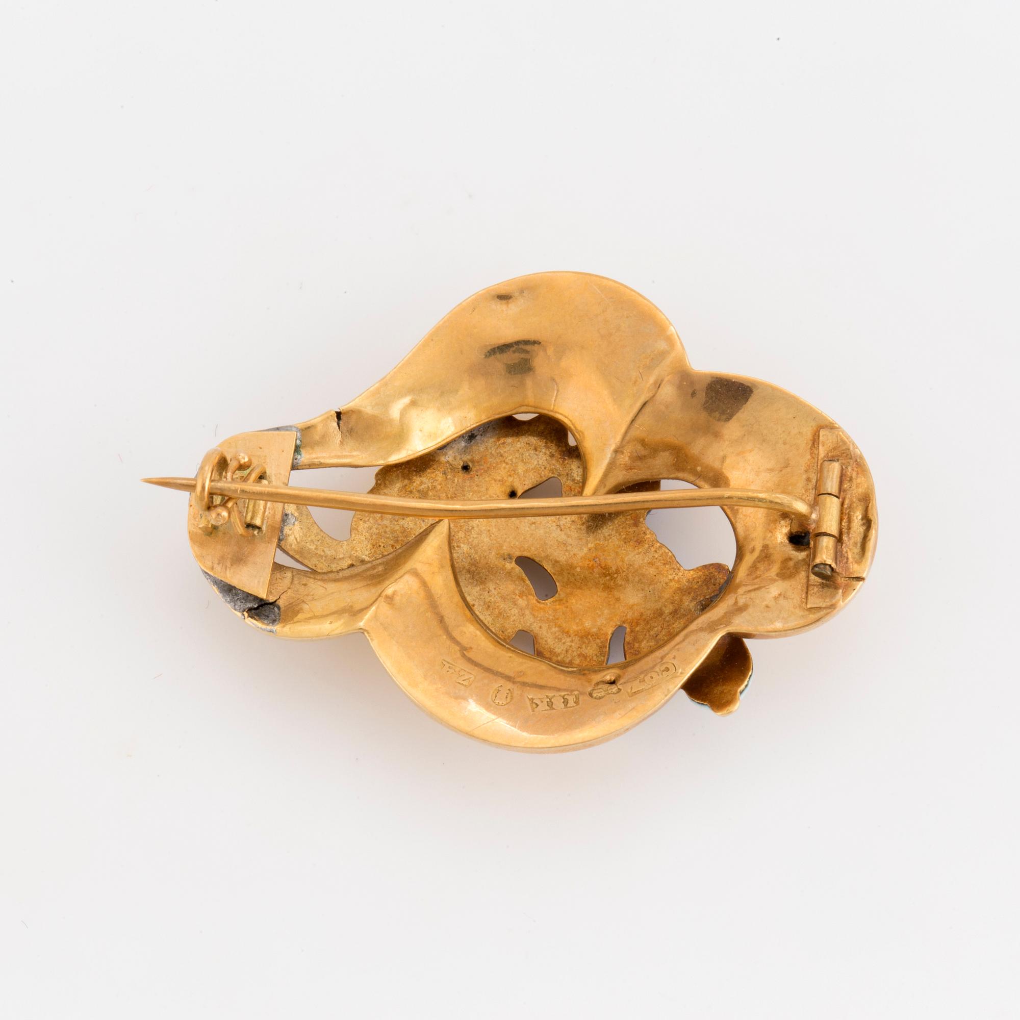 A blue and white emamelled brooch with a floral motif.