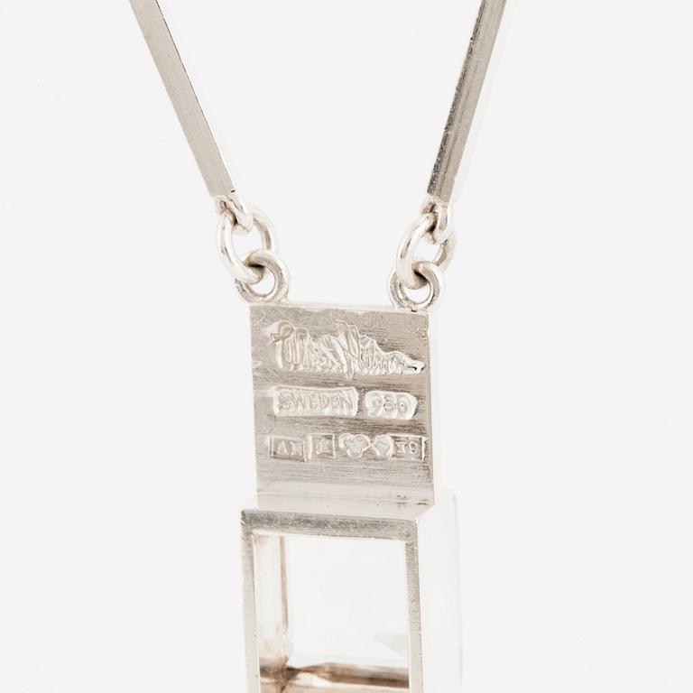 Wiwen Nilsson, hängsmycke i form av ett kors i silver med fasettslipad bergkristall, Lund 1973.
