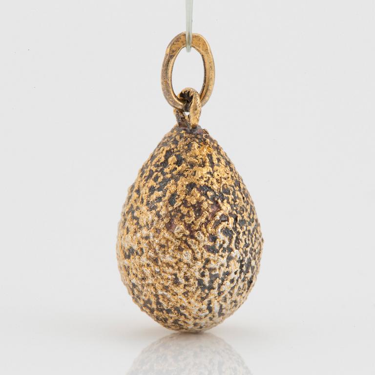 An egg pendant in silver with faceted paste.