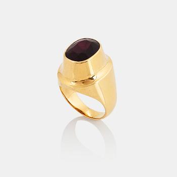 A Sigurd Persson 18K gold ring set with a faceted garnet.