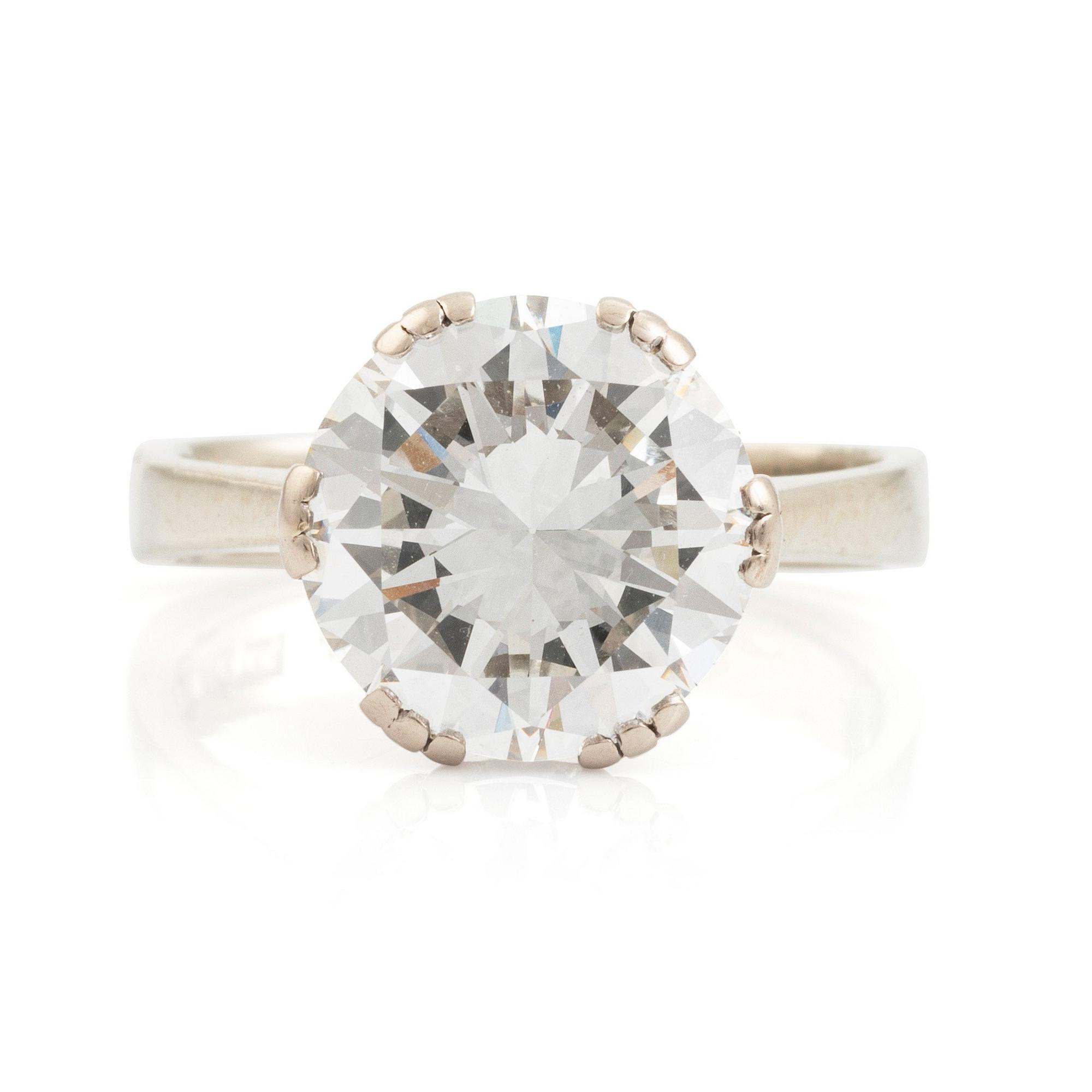 An 18K white gold ring set with a round brilliant-cut diamond.