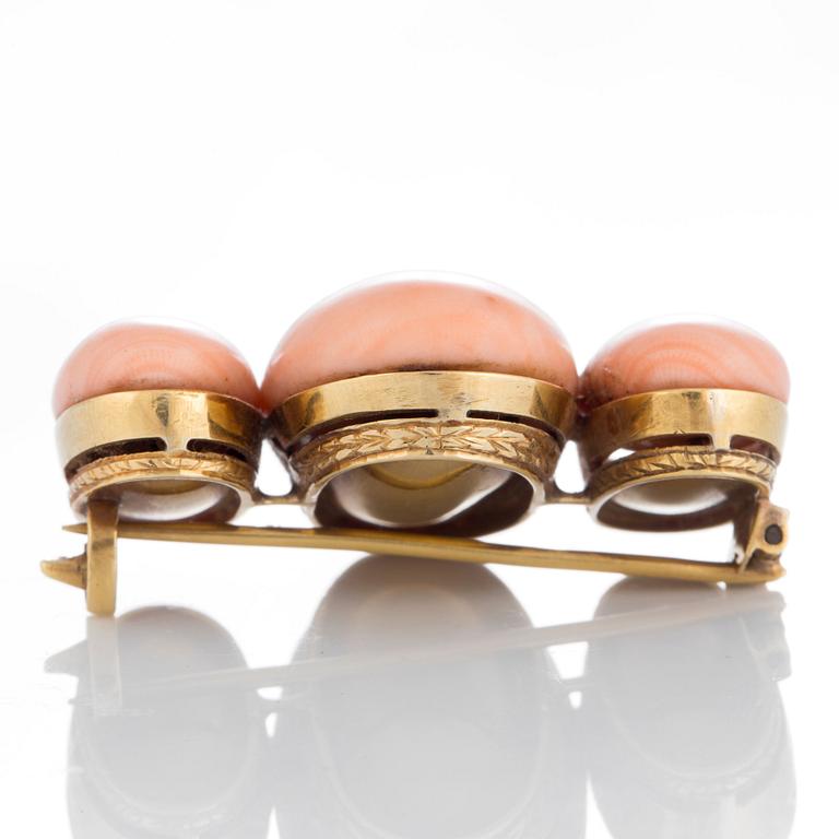 A coral brooch in 18K gold.