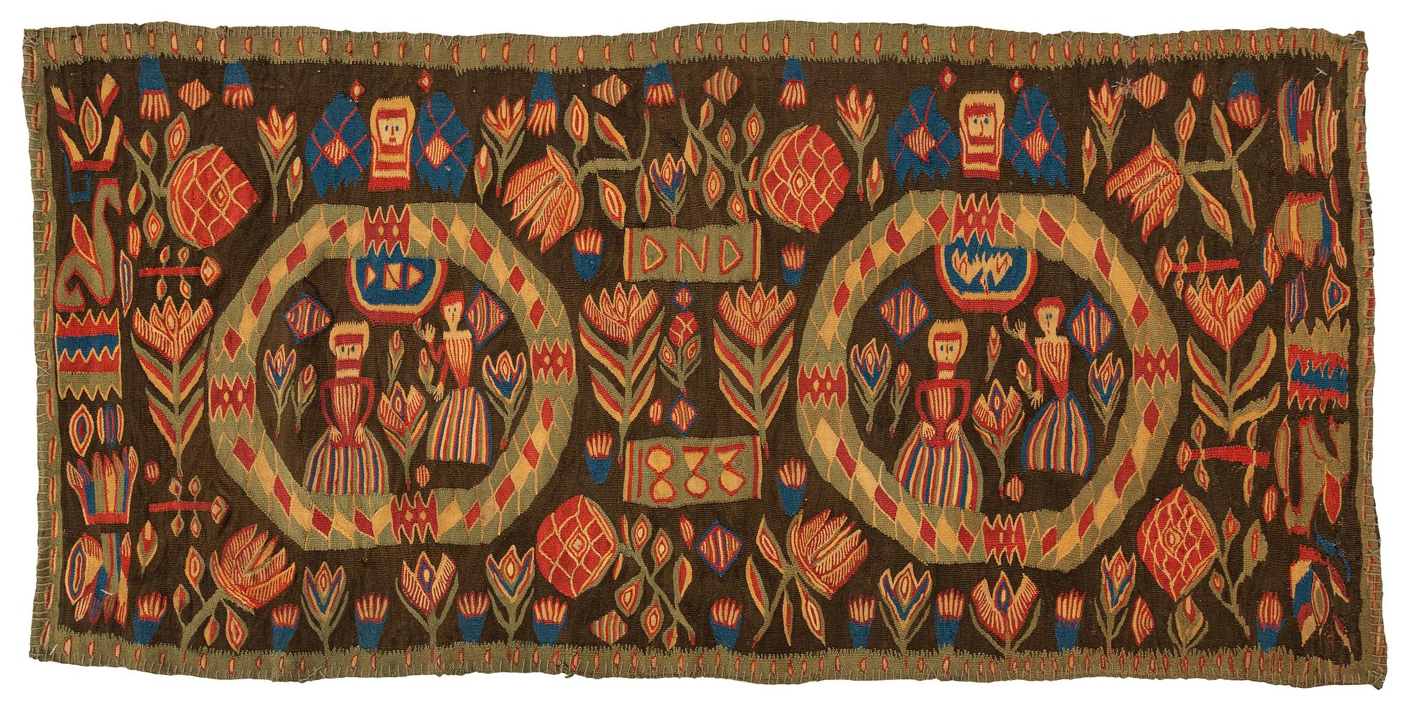 A carriage cushion, "the Annunciation", tapestry weave, ca 103 x 51 cm, south western Scania (Sweden), 1833.