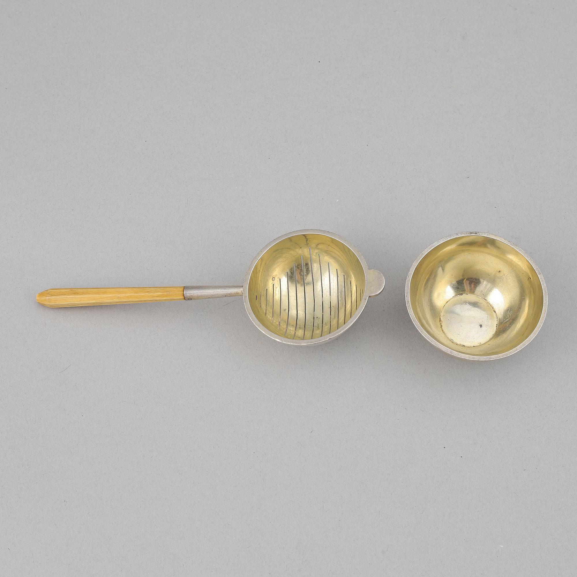A silver and wood tea strainer by Wiwen Nilsson, Lund, 1932.