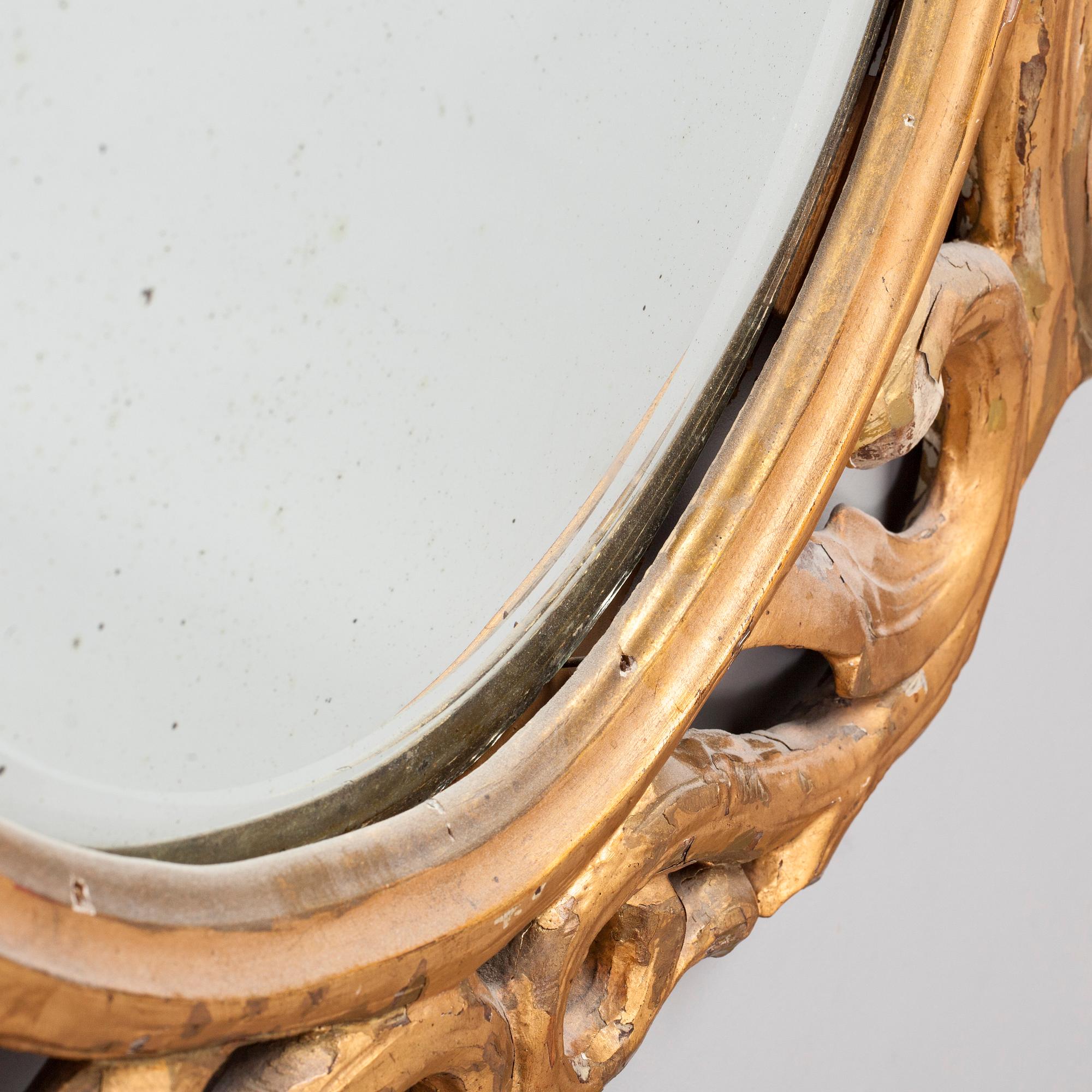 A gilded and bronzed woodcut leaf decorated mirror, second half of the 19th century.
