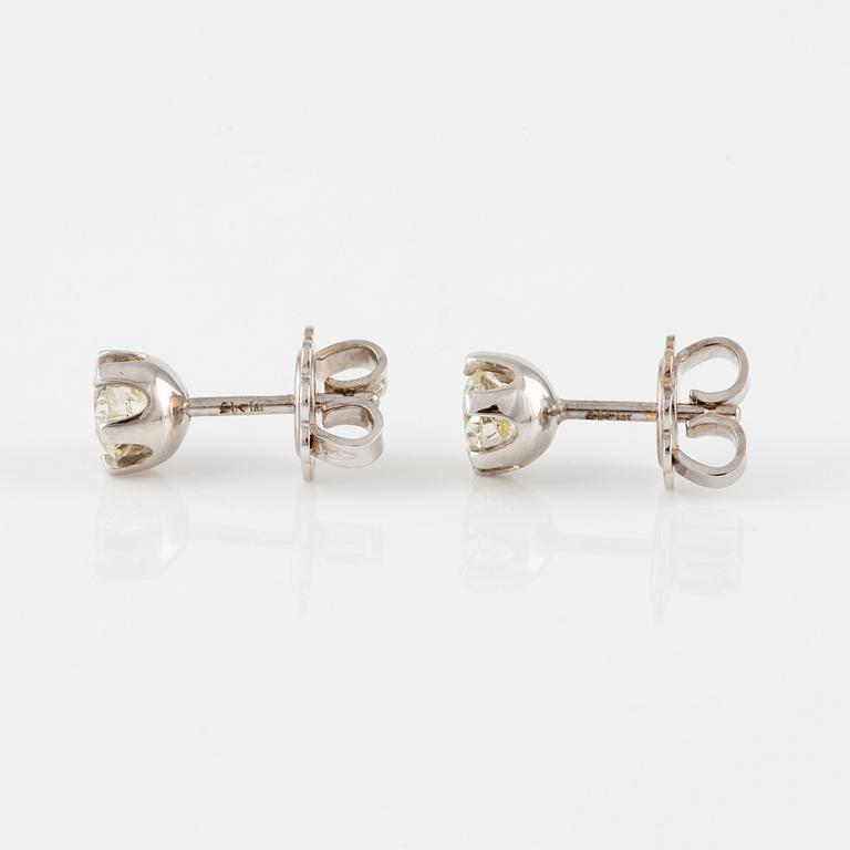 A pair of 14K gold earrings with round brilliant-cut diamonds.