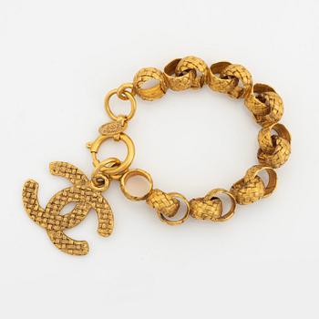 Chanel, a gold tone bracelet.