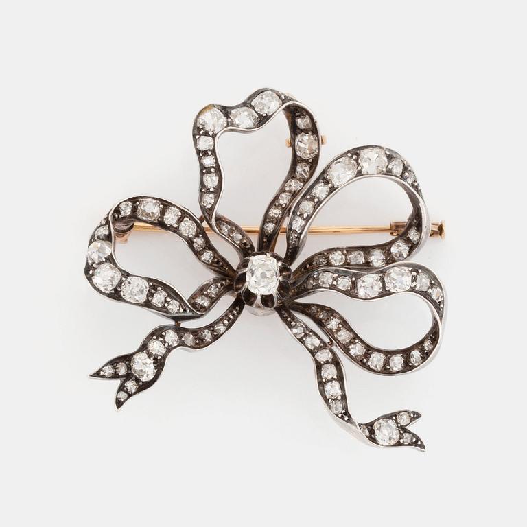 A silver and 14K gold bow brooch/pendant set with old- and rose-cut diamonds.