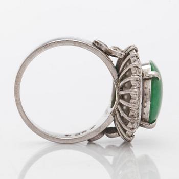 A palladium-plated silver ring with cabochon-cut jadeite and diamonds.