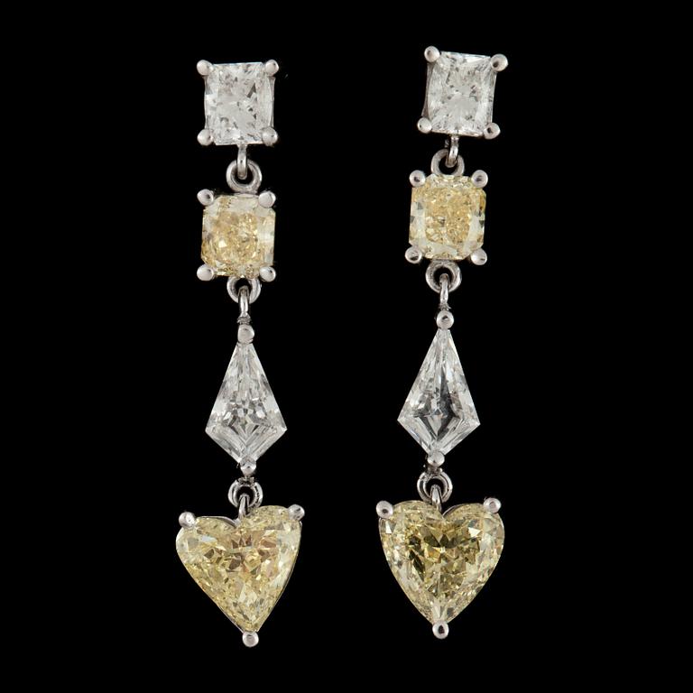 A pair of fancy yellow and colourless diamond earrings.