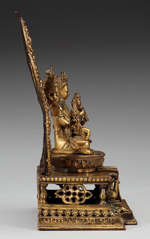 A large gilt bronze Nepal/Sino-Tibetan figure of Buddha, Qing dynasty, presumably Qianlong (1736-95). With an inscription around the base.