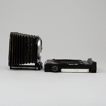 A black Mamiya RZ67 Pro Medium Format Camera Body with sekor z f = 110 mm 1:2.8 and sekor c f = 50 mm 1:4.5 lens.