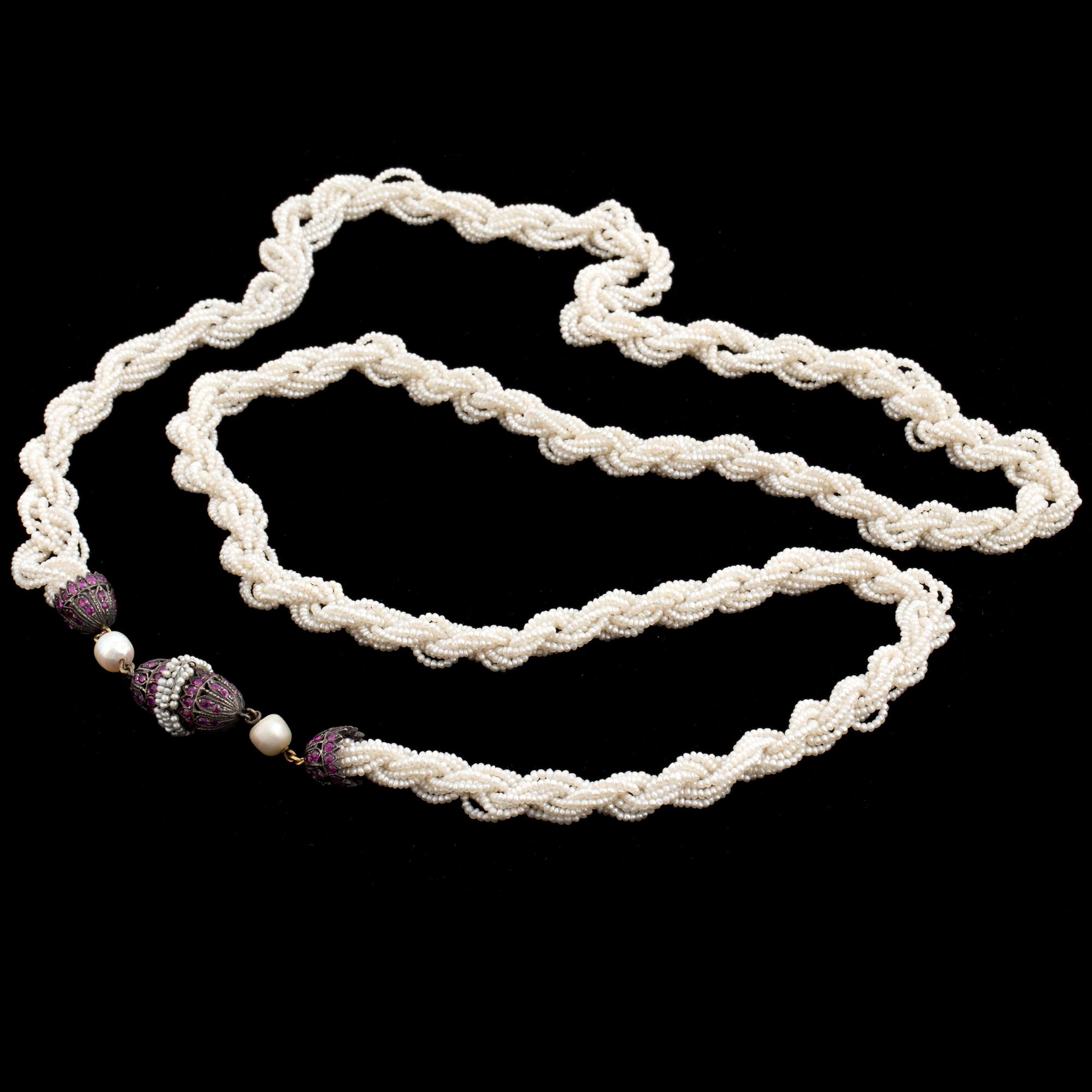 A necklace of cultured pearls and seed pearls with a silver clasp decorated with probably synthetic rubies.