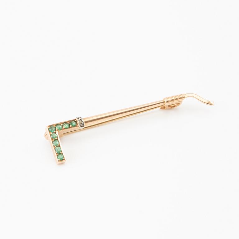 Brooch in the shape of a riding crop, 8K gold with faceted emeralds and rose-cut diamonds.