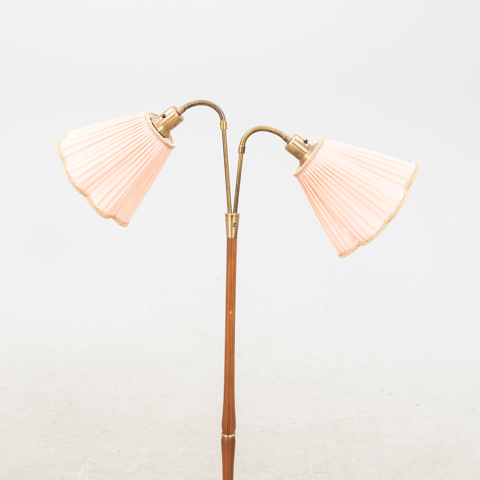 A teak and brass floor lamp from the first half of the 20th century.