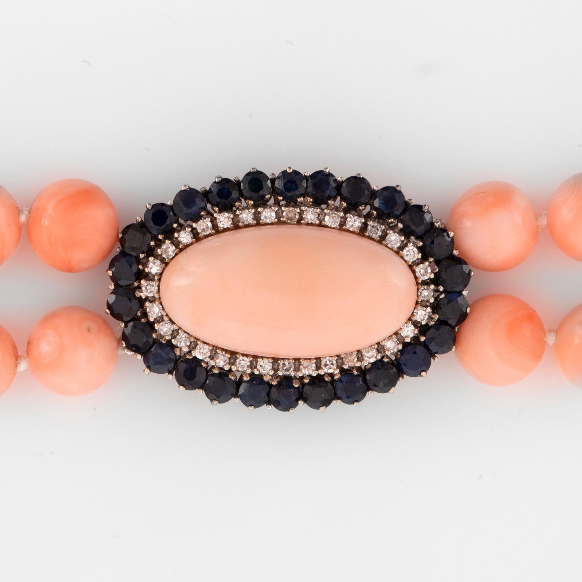 A coral necklace. Clasp with coral, sapphire and diamonds.