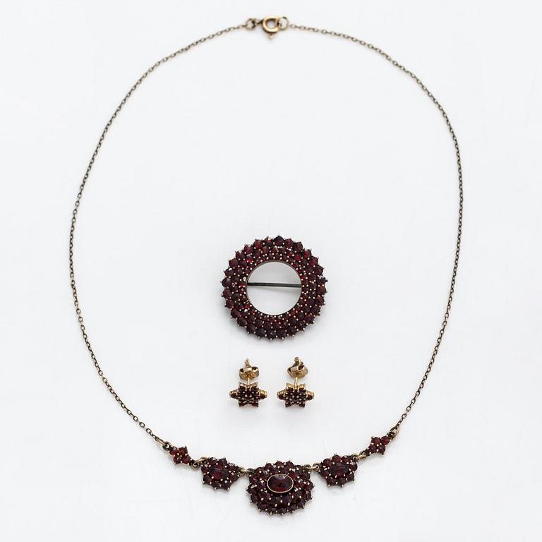 A necklace, brooch and earrings, gilded silver and garnets.