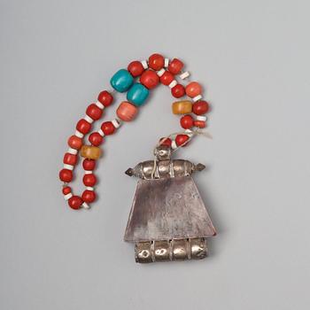 A silvered copper alloy pendant with beads, Tibet, late 19th Century.