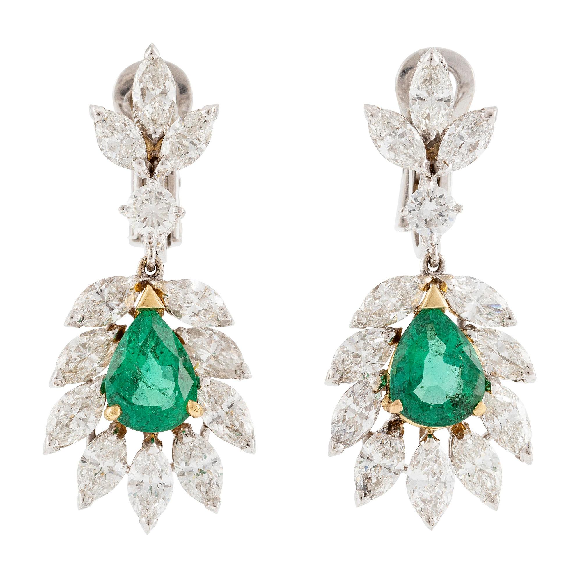 A pair of earrings in 18K white gold with drop-shaped faceted emeralds and diamonds.