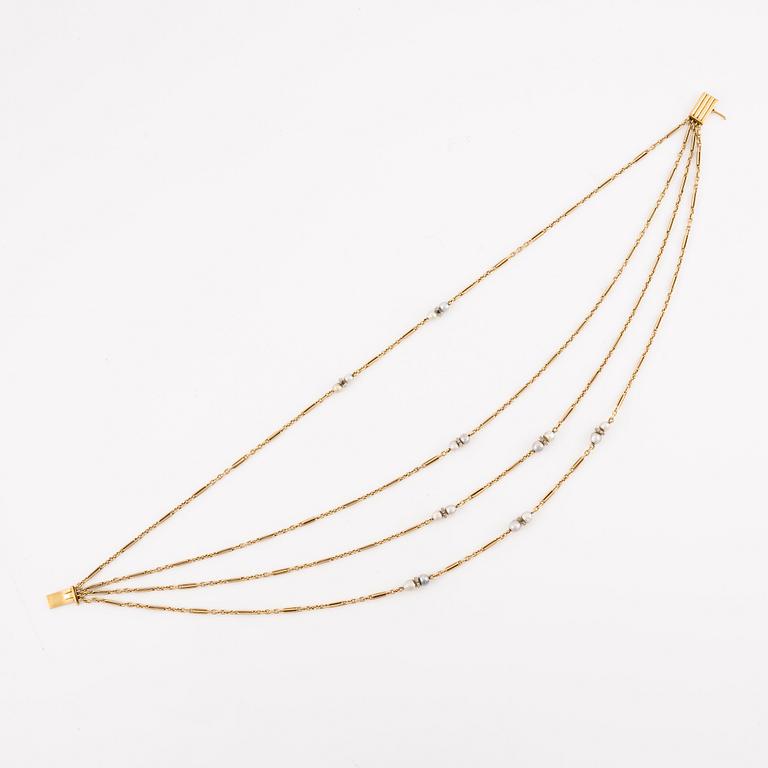 A W.A. Bolin necklace in 18K gold with pearls and white discs.