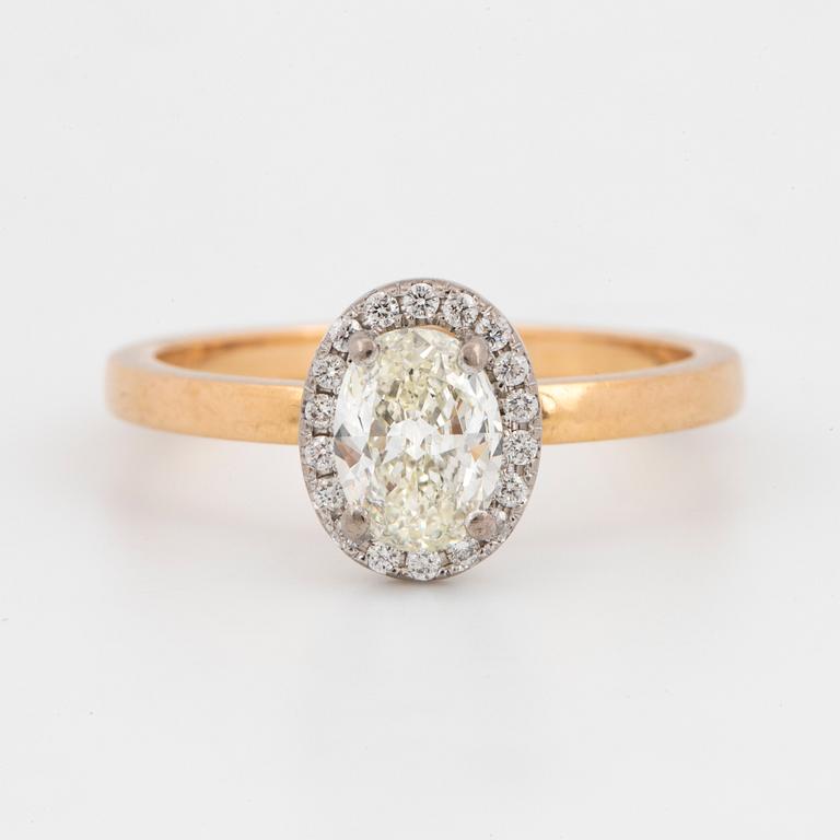 An 18k gold ring set with an oval brilliant-cut diamond.