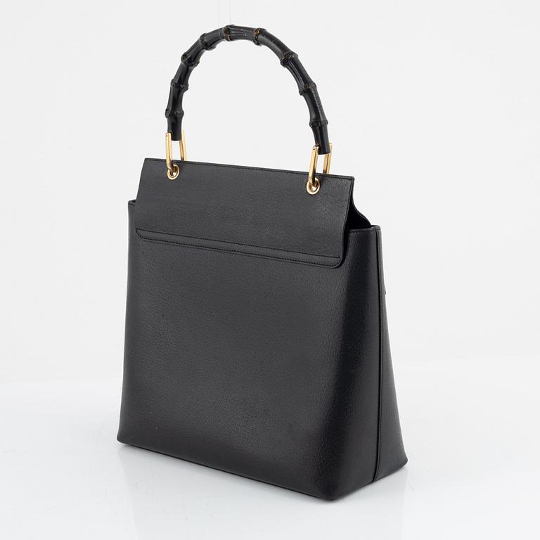 Gucci, a black leather and bamboo bag.