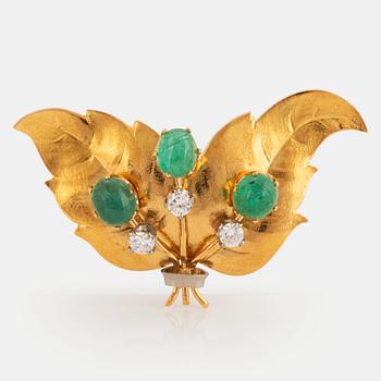 An 18K gold brooch set with emeralds and round brilliant-cut diamonds.