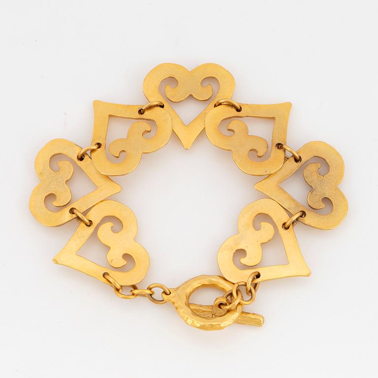 YVES SAINT LAURENT, Hammered gilt metal bracelet, links designed as hearts.