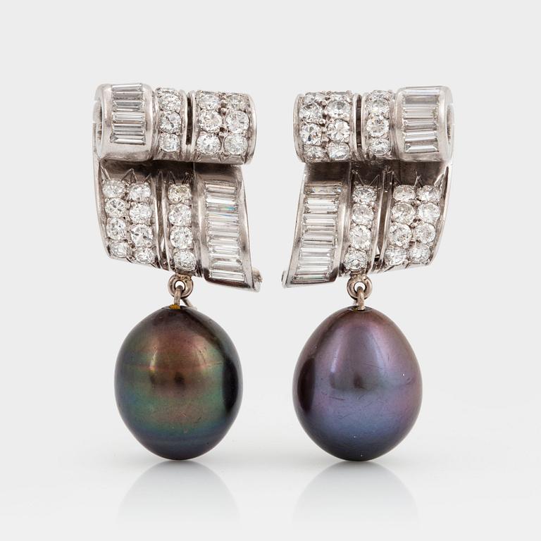 A pair of platinum earrings set with baguette- and old-cut diamonds.