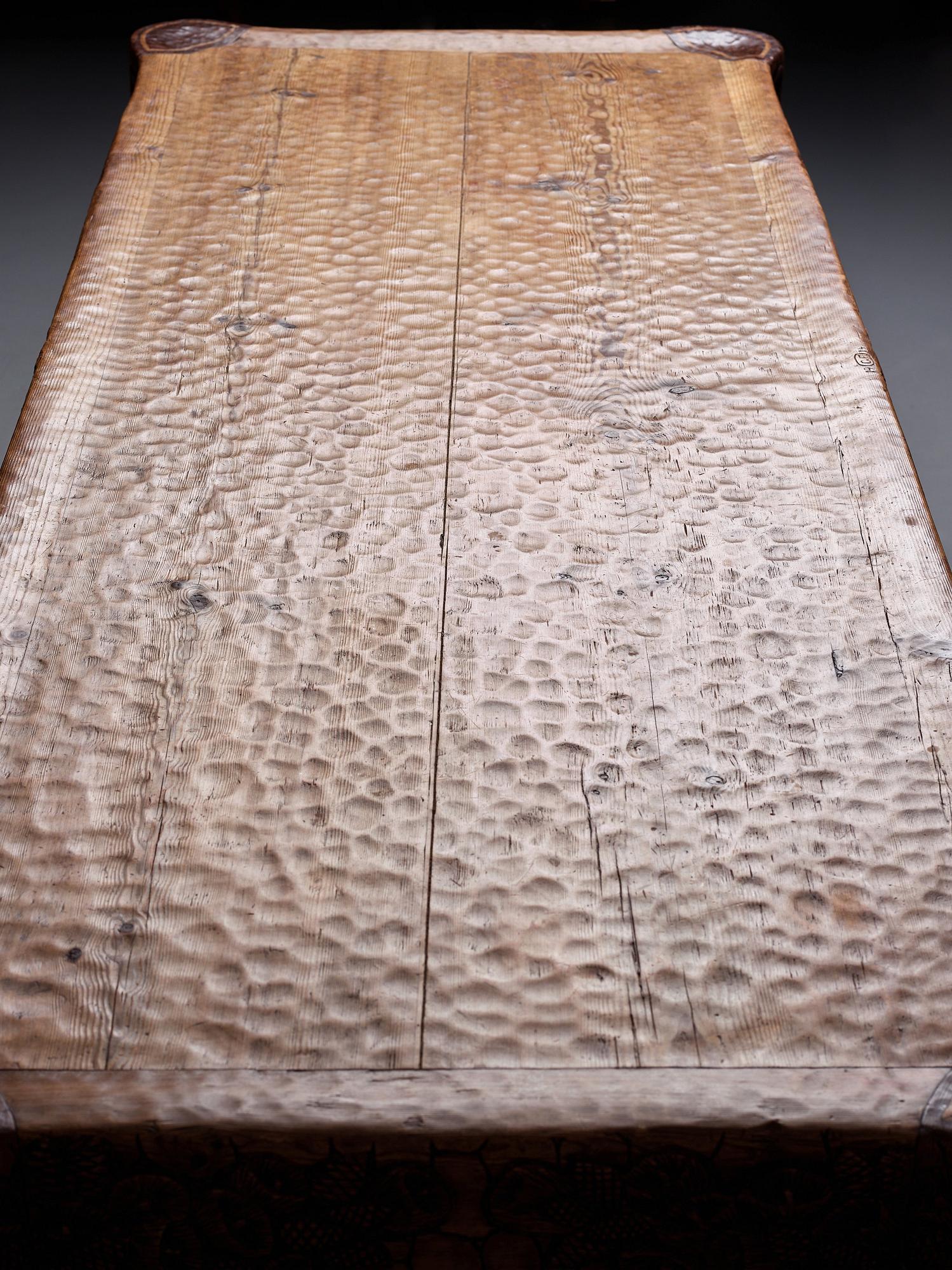 Gustaf Fjaestad, an Art Nouveau carved pine table, Arvika Sweden 1914, a double to the table in the Thiel Collection,