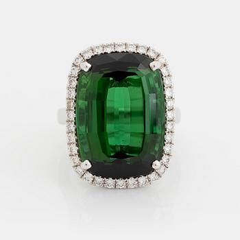 438. An 18K white gold ring set with a faceted green tourmaline and round brilliant-cut diamonds.