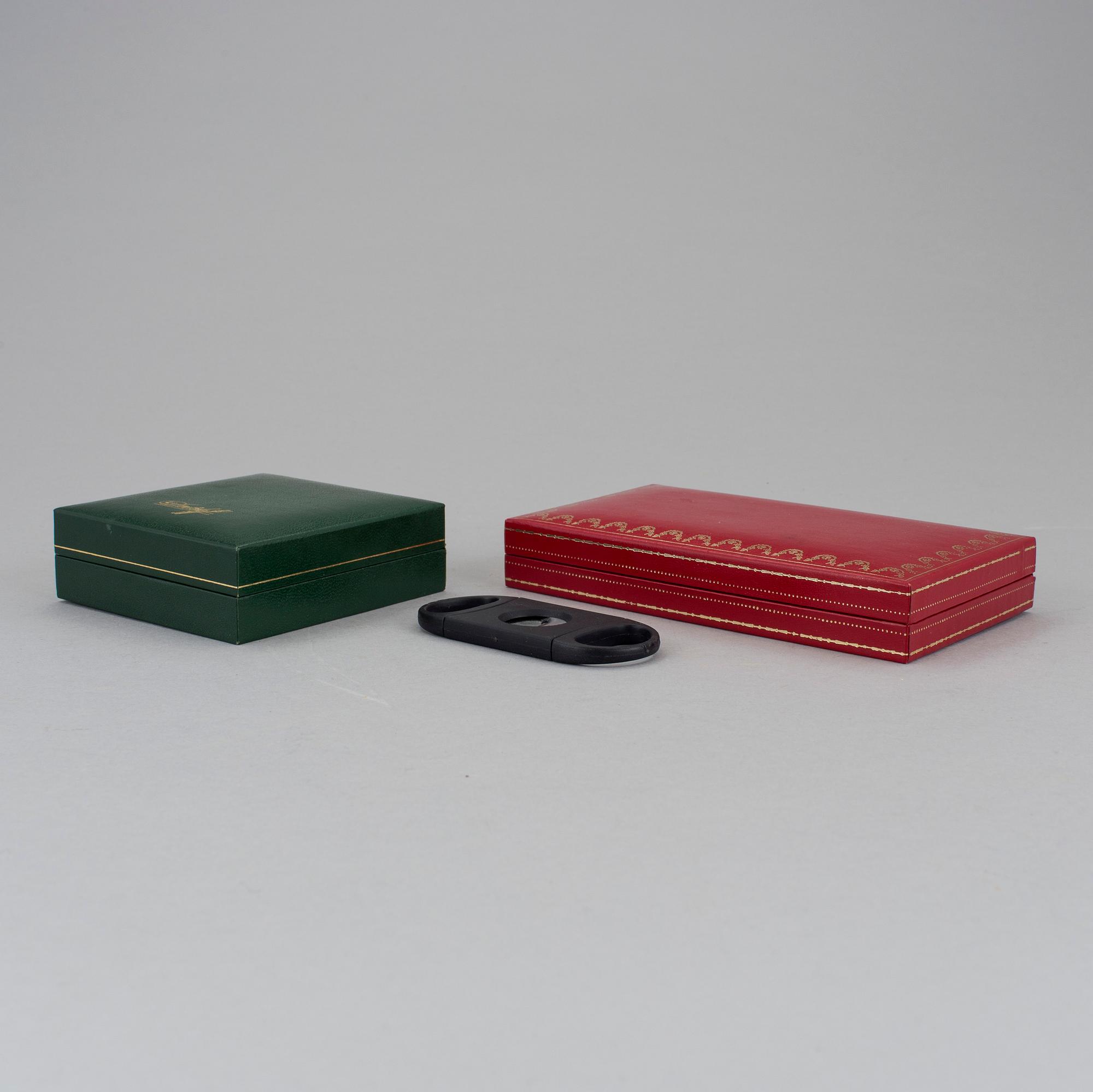 Two cigar cutters from Davidoff and must de Cartier in original cases.