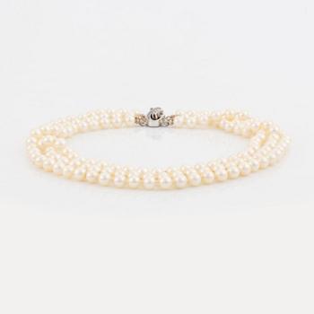 Three strand cultured pearl necklace, clasp with diamonds.
