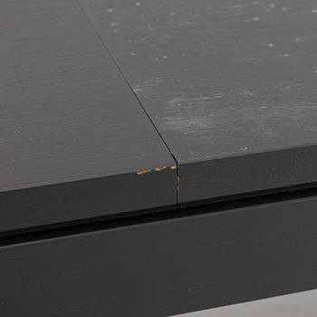 A black oak dining table with two additional leaves.