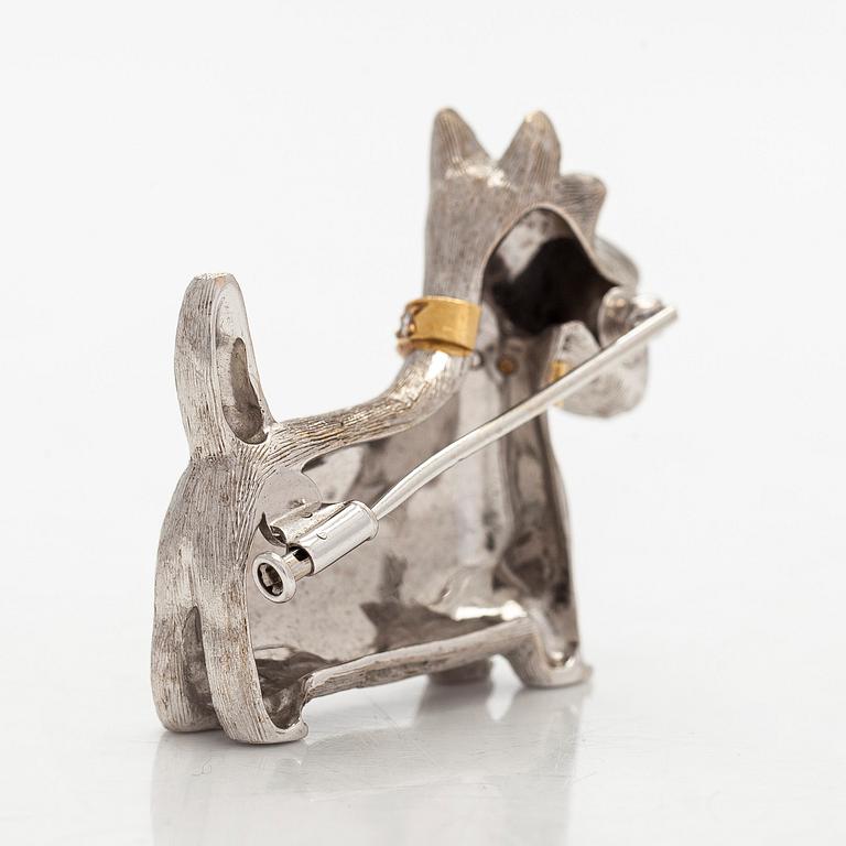 Rintaneula, 18K valkokultaa, sekä granaatteja ja briljanttihiottuja timantteja. BW&Co, Lontoo.