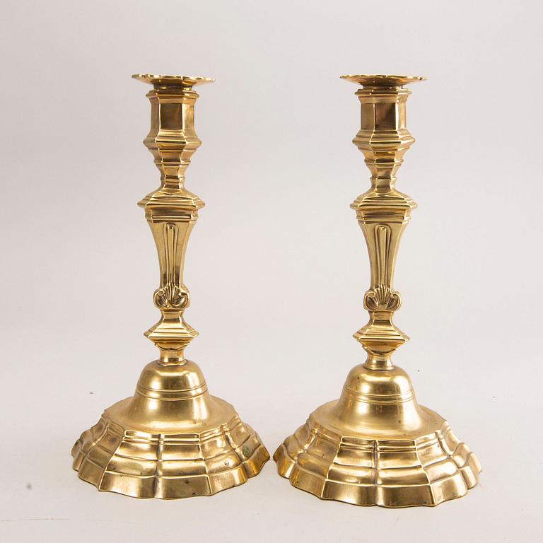 A pair of rococo brass candlesticks, possibly France.
