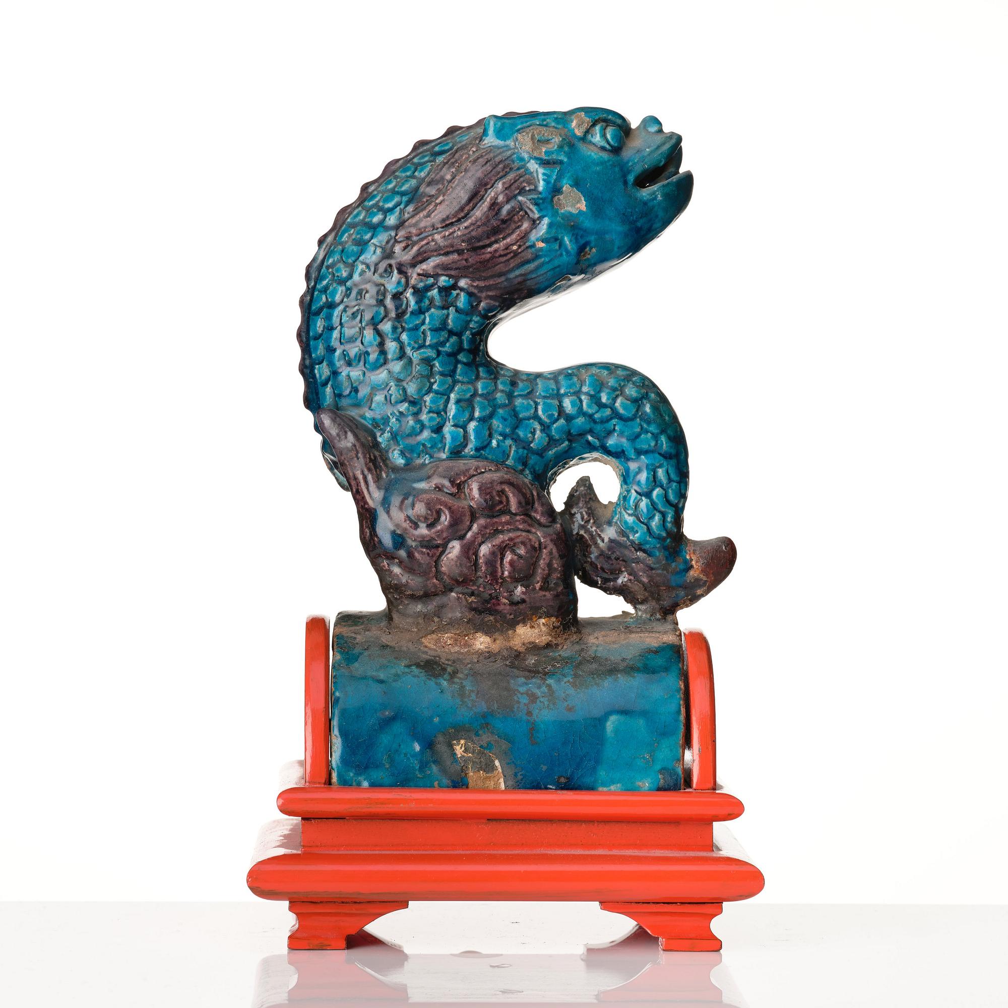 A turkoise and abuergine glazed roof tile in the shape of a fish, Ming dynasty (1368-1644).