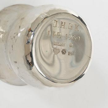 A pair of beakers, two napkin rings, and 17 pieces of cutlery, silver.