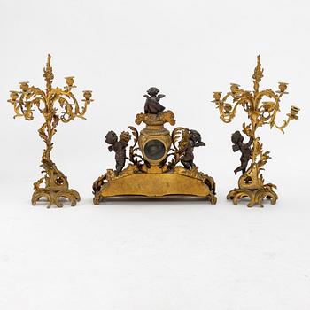 A grand mantle piece set with a clock and a pair of candelabras, Louis XV-style, second half of the 19th century.