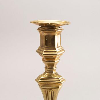 A pair of rococo brass candlesticks, possibly France.