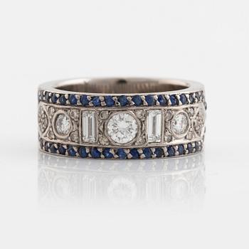 An 18K white gold ring set with diamonds, rubies and sapphires.