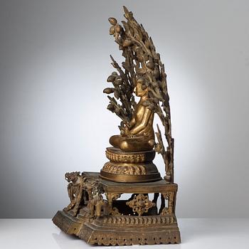 A large Nepalese gilt bronze buddha on a throne with mandorla, 18/19th Century.