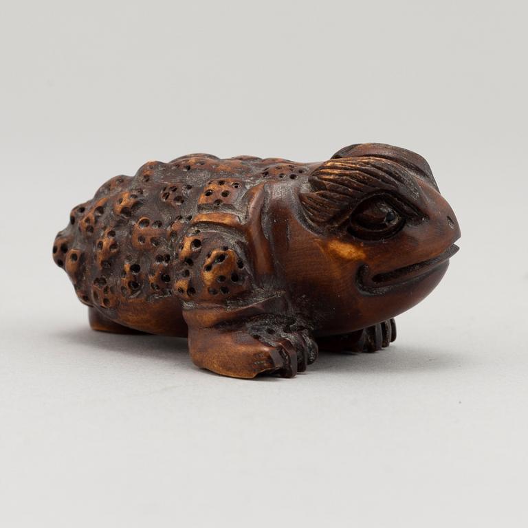 A carved wooden netsuke in the shape of a frog, 20th century.