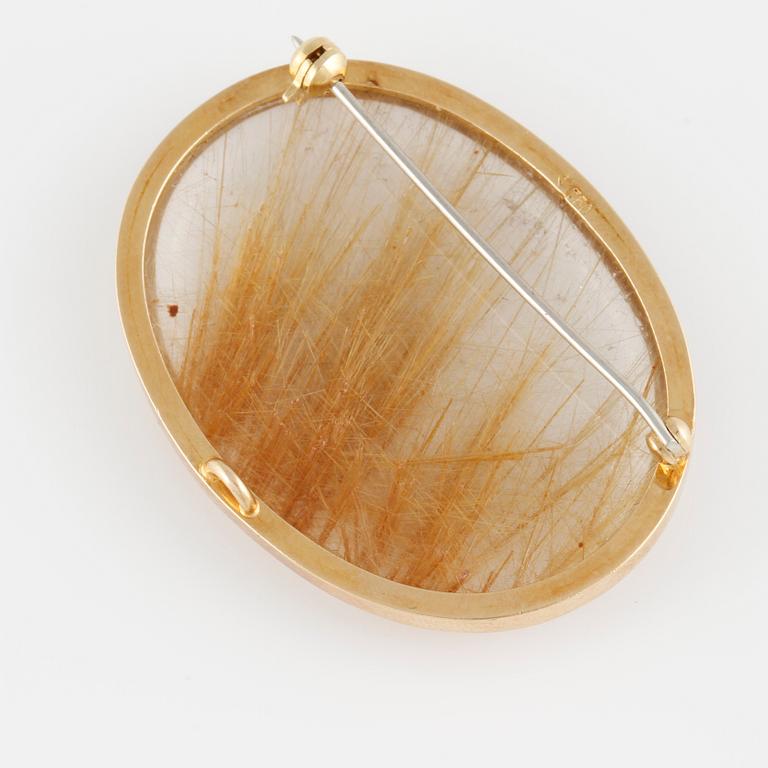 BROSCH, 18K guld med cabochonslipad rutilkvarts. Vikt 17,5 gram.