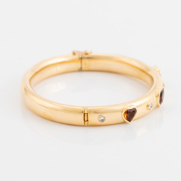 An 18K gold David Morris bangle set with citrines and round brilliant-cut diamonds.