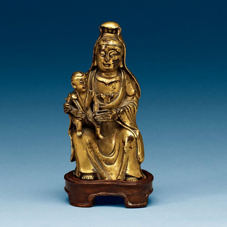 A seated gilt bronze figure of Guanyin with a small boy, Qing dynasty, 18th Century.