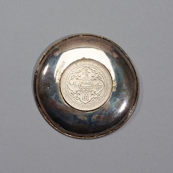 A small silver plate with a One Dollar coin, Qing Dynasty, Guangxu 1899.