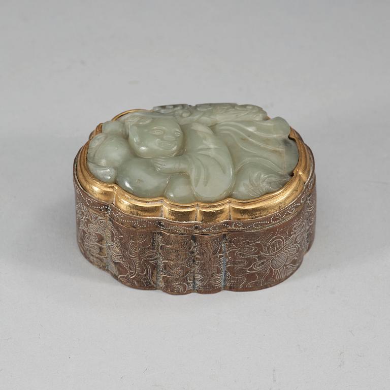 A partly gilded metal box with cover, mounted with a carved pale celadon nephrite plaque. Late Qing dynasty (1644-1912).