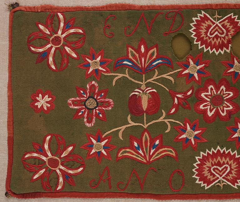 An embroidered carriage cushion, ca 51 x 113 cm (with mounting 61 x 122 cm) signed and dated END JPLG ANO 1838, Scania.