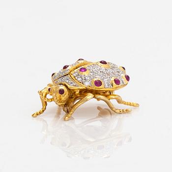 An 18K gold ladybug brooch, with rubies and diamonds.